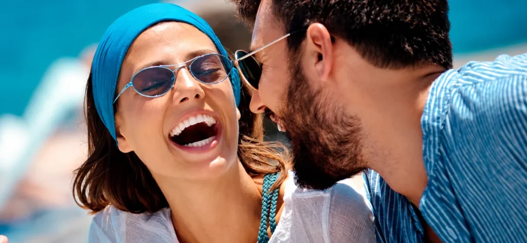 Dos personas compartiendo un momento alegre al aire libre; imagen ilustrativa
